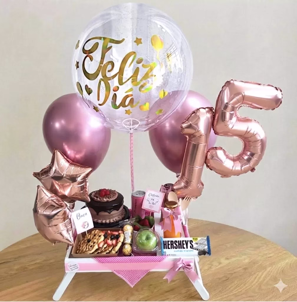 Desayuno sorpresa para quinceañera en Bogotá con mesa de madera, globos y dulces.