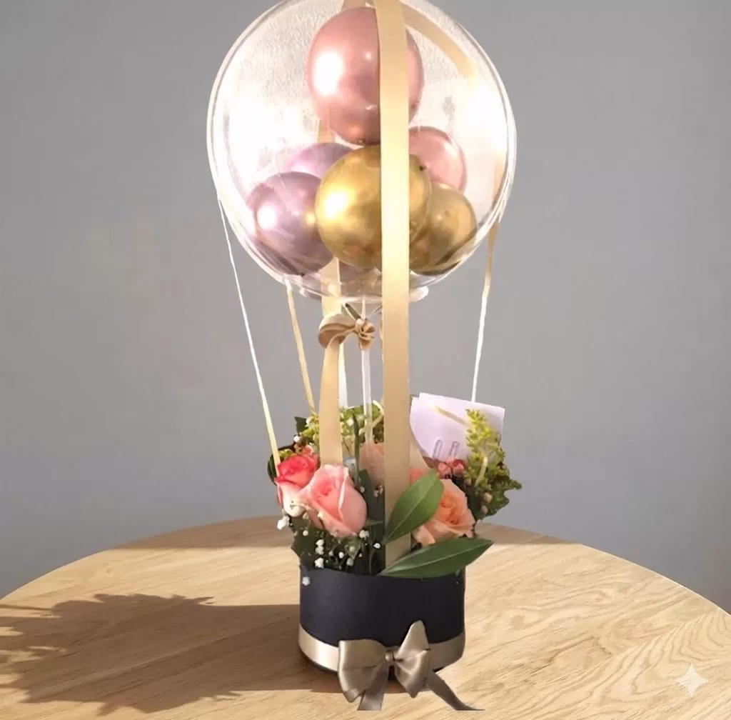 Arreglo de flores en forma de globo aerostático con globo burbuja y globos cromados en Bogotá.