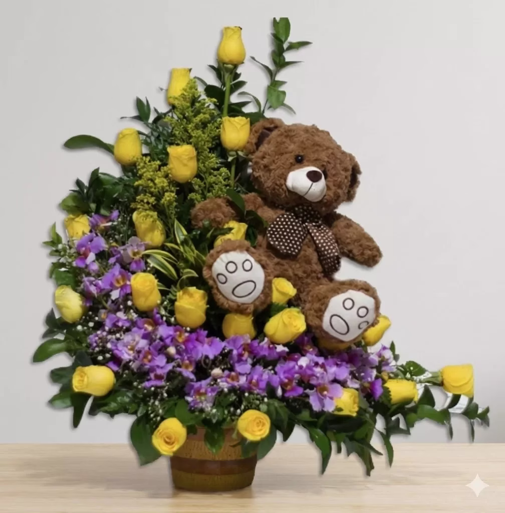 Arreglo floral de orquídeas y rosas sobre base rústica de madera con peluche, para entrega a domicilio en Bogotá.