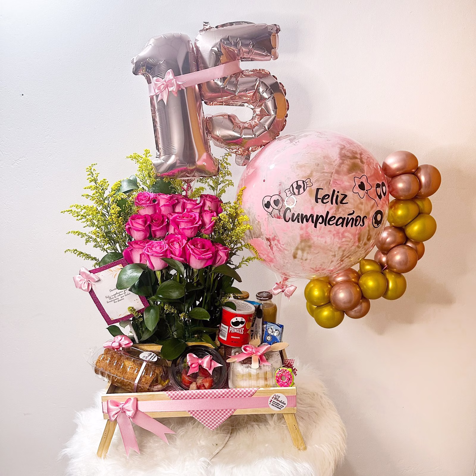 Desayuno Sorpresa de Quince Años con mesa de madera, flores y globos en Bogotá.