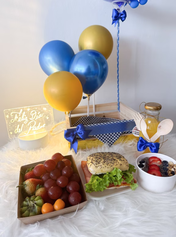 Canasta de madera con desayuno sorpresa para papá, incluyendo frutas, sandwich y parfait. - Amordidas
