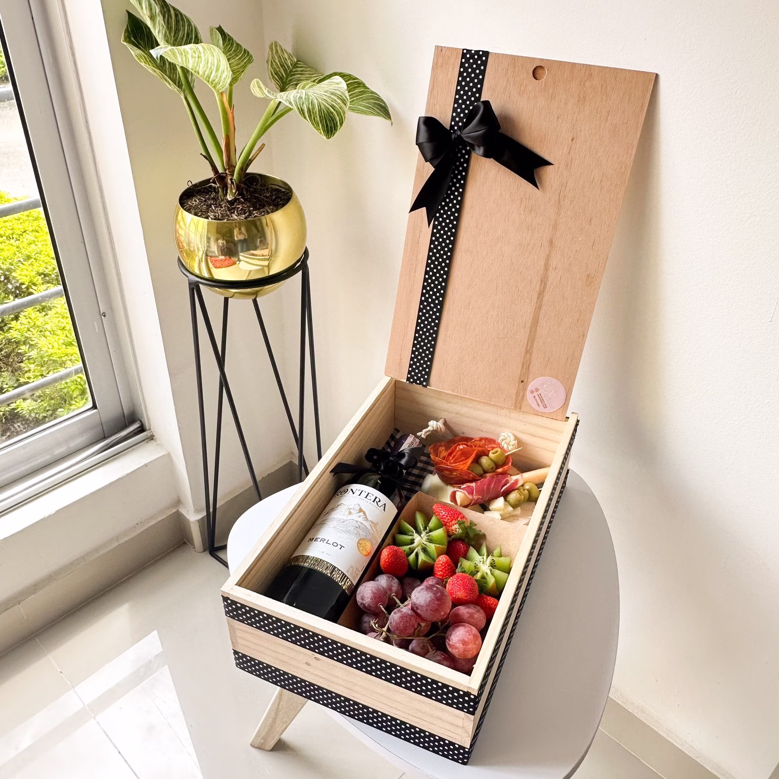 Ancheta Corporativa Bogotá 'Delicias Compartidas' con vino, salami, queso y frutas en caja de madera.