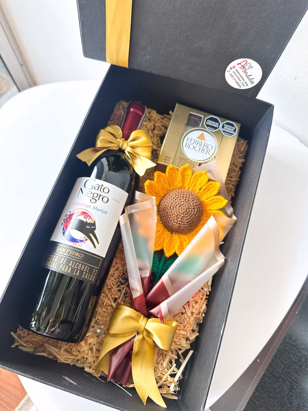 Ancheta corporativa de lujo en Bogotá con botella Gato Negro, Ferreros y girasol en crochet.
