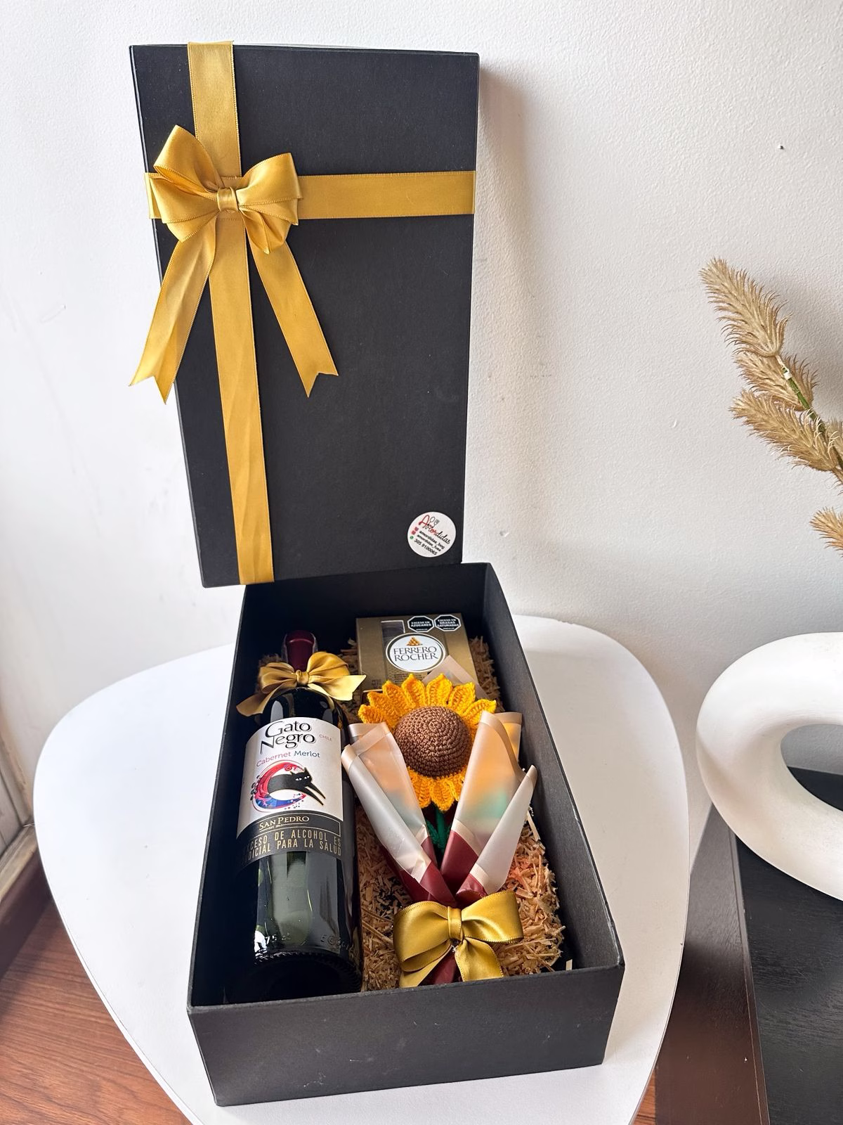 Ancheta corporativa de lujo en Bogotá con botella Gato Negro, Ferreros y girasol en crochet. - Amordidas